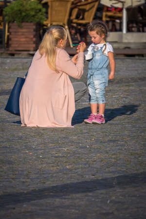 Bydgoszcz, Poland -  August 2017 :  Mother and daughter eating ice cream on the street in the Old Town squareのeditorial素材