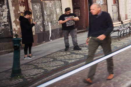 Bydgoszcz, Poland -  August 2017 : Car side reflection of a young men standing on the street and texting on his smartphonesのeditorial素材