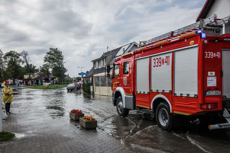 Sarbinowo, Poland -  August 2017 : Fire engine arriving to pump up excess water from flooded road...