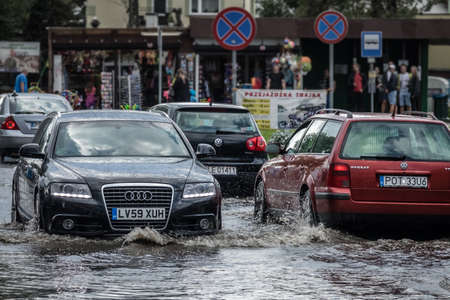 Sarbinowo, Poland -  August 2017 : Cars going through the flooded street after extremely heavy...