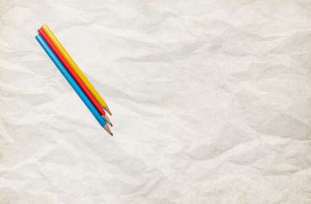 Red, yellow and blue crayons and white paper sheet on the deskの写真素材