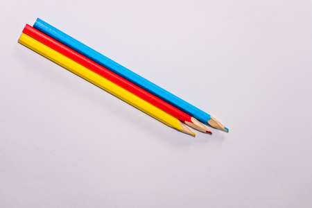 Red, yellow and blue crayons and white paper sheet on the deskの写真素材
