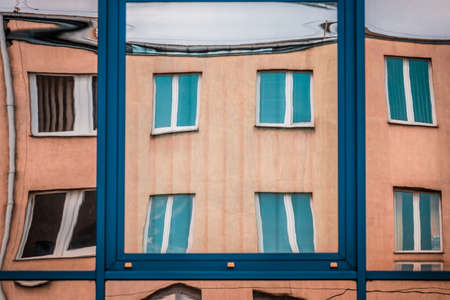 Distorted apartment reflection in the windows of an office buildingの写真素材