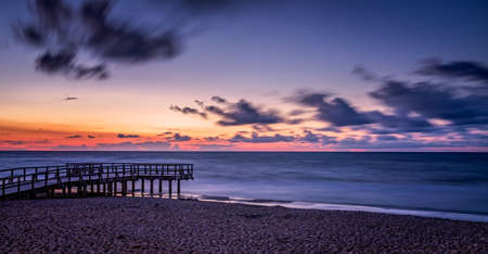 Panoramic picture of a sunset over wooden pier on the sea beach in Sarbinowo, Baltic Sea, Polandの写真素材
