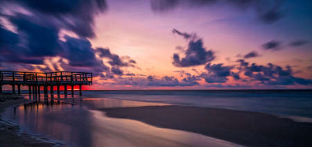 Panoramic picture of a sunset over wooden pier on the sea beach in Sarbinowo, Baltic Sea, Poland