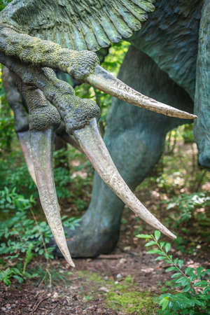 Solec Kujawski, Poland -  August 2017 :  Life sized Therizinosaurus scythe lizard dinosaur statue in a forestのeditorial素材