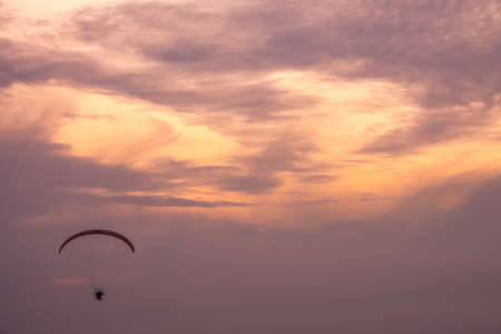 Sarbinowo, Poland -  August 2017 : Paraglider flying with a paramotor during beautiful sunsetのeditorial素材