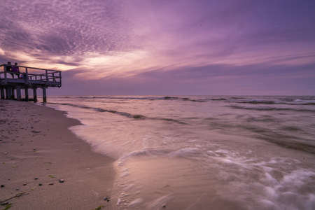Sarbinowo, Poland -  August 2017 :  Picture of a sunset over wooden pier on the sea beach in Sarbinowo, Baltic Sea, Polandのeditorial素材
