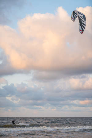 Sarbinowo, Poland -  August 2017 :  Extreme sport performer parachute surfing in the rough sea at duskのeditorial素材