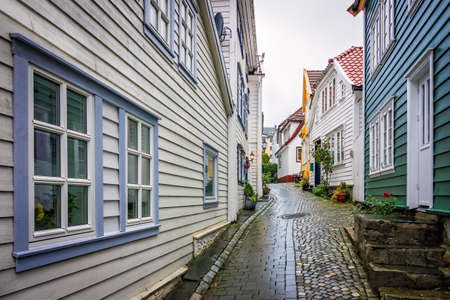 Narrow cobble stoned streets between traditional old colorful houses in the old part of Bergen town, Norwayの写真素材