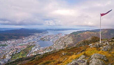 Norwegian flag fluttering on a wind on a pole on top of Mount Ulriken, Bergen, Norwayの写真素材