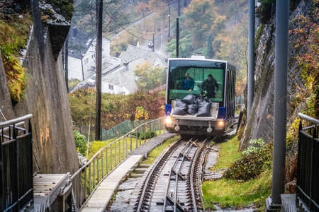 Bergen, Norway -  October 2017 :  Man unloading black bags filled with maintenance materials from the Floibanen funicular heading to the final station at the top of the Mount Floyen, Bergen, Norwayのeditorial素材