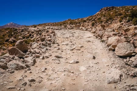 Mountain road formed of large rocks, stones and boulders through remote part of southern Altiplano, Boliviaの写真素材