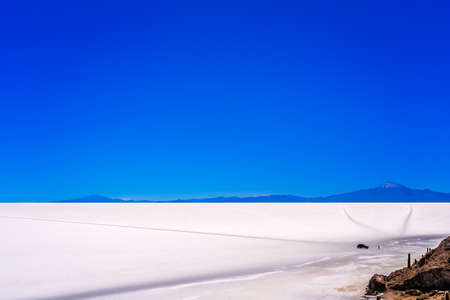 Four wheel car with touriusts in front of the Cactus island in the middle of Salar de Uyuni in Boliviaの写真素材