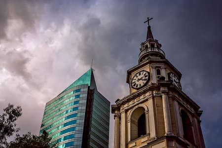 Old church clock tower and modern highrise apartment in Santiago, Chile, South Americaの写真素材