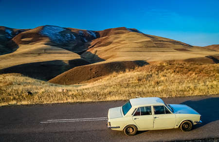 White paykan car stopping en routh through the pass in the beautiful Alamut mountains in the...