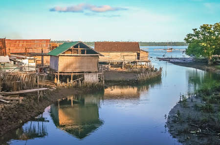 Small wooden bamboo huts on the riverbank on the Indonesian island of Sumbavaの写真素材