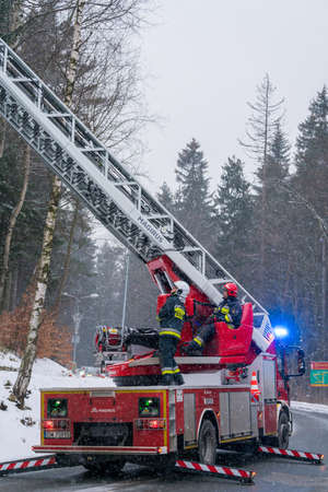 Karpacz, Poland -  February 2018 : Firefighters in action on a fire engine with the extendable crane...