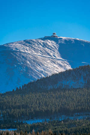 Sniezka mountain, the highest peak in Karkonosze mountain range on a sunny winter day as seen from Karpacz ski resort, Polandの写真素材