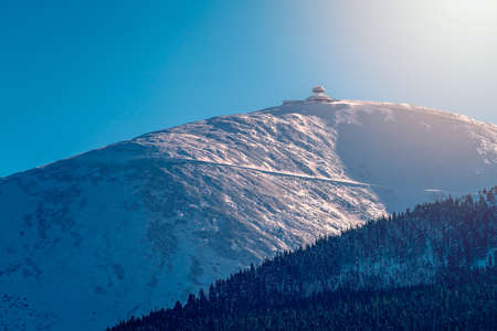 Sniezka mountain, the highest peak in Karkonosze mountain range on a sunny winter day as seen from Karpacz ski resort, Polandの写真素材