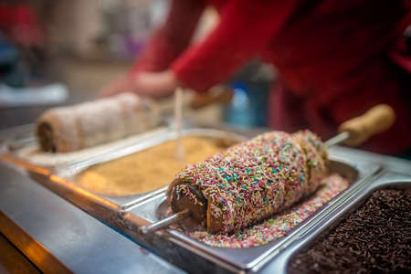 Person preparing sweet round waffle called Hungarian kolacz inside a street sweet shop in Karpacz, Polandの写真素材