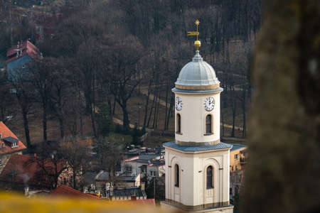 High clock tower of the Saint Jadwiga Catholic church in Bolkow town in Lower Silesia, Poland, as seen from the walls of the Bolkow castleの写真素材