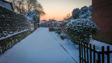 London, England -  February 2018 : Snow covering alleyway to the properties in the early morning in London suburb after the Beast from the East storm Emma brought heavy snowfallの写真素材