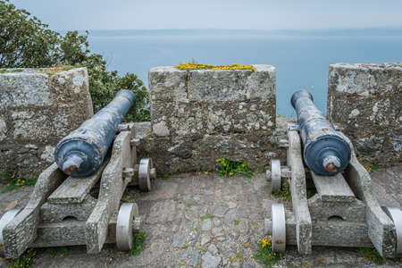 Two large brass cannons on the external defensive walls of St Michaels Mount fortress, Marazion near Penzance, Cornwall, UKの写真素材