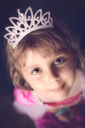 Little fairy princess looking up with diamond crown on her headの写真素材