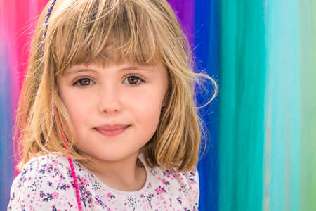 Portrait of a cute little Caucasian toddler girl with colorful backgroundの写真素材