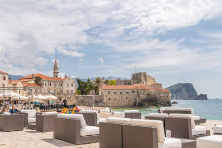 Budva, Montenegro - April 2018 : Large empty lounge chairs waiting for tourists on the beach outside a cafe and restaurantのeditorial素材