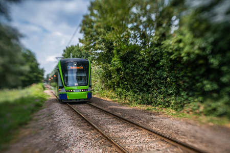 London, England -  July 2018 : Modern tramway on tracks going through the forestのeditorial素材