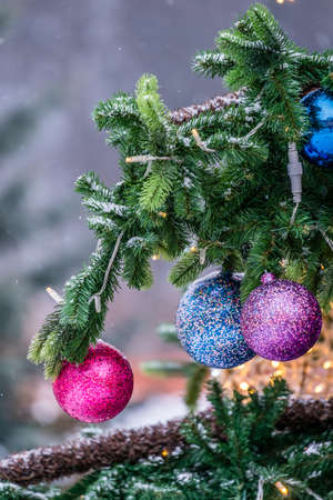 Colorful Christmas decorations hanging from the branches of the Christmas tree in Decemberの写真素材
