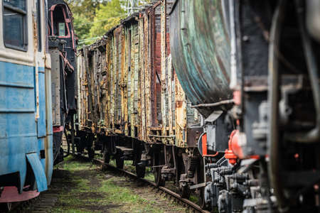 An old disused retro freight train wagons and cars on the side trackのeditorial素材