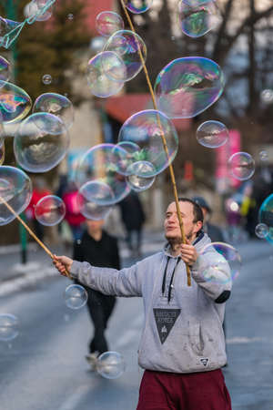 Karpacz, Poland - February 2018 : Man releasing giant soap bubbles for children to catch on the main high street in Karpacz town, polish winter ski resortのeditorial素材