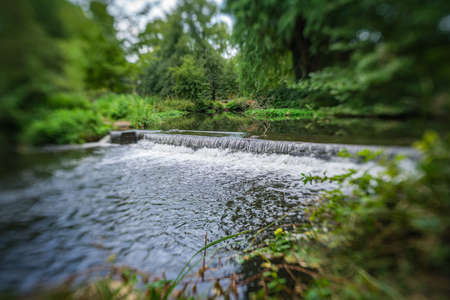 Small waterfall on a river in Morden Hall Park Park, London, UK