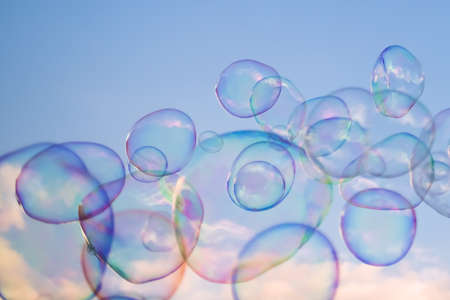 Giant soap bubbles floating high in the air with the blue sky in the backgroundの写真素材