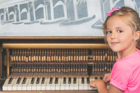 Little young caucasian girl playing on the piano outside train stationの写真素材