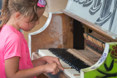 Little young caucasian girl playing on the piano outside train stationの写真素材