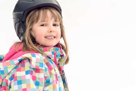 Winter portrait of a little girl wearing ski helmet during skiing lessonの写真素材