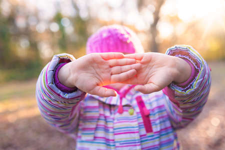 Portrait of young caucasian girl holding her in front of her face in a gesture suggesting to leave her aloneの写真素材