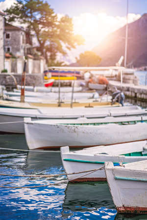 Anchored fishing boats on the shore in the beautiful Perast town in the Kotor Bay, Montenegroの写真素材