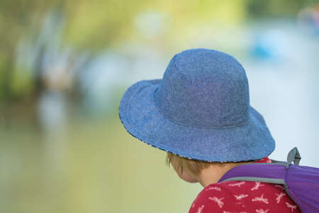 Caucasian woman with a blue hat resting in a park in summerの写真素材