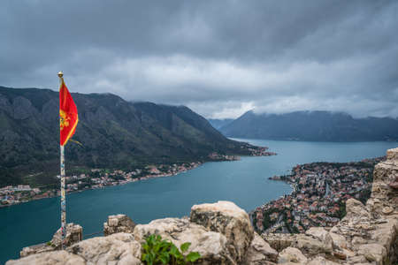 Kotor, Montenegro - April 2018 : National flag of Montenegro fluttering in the wind on top of the...