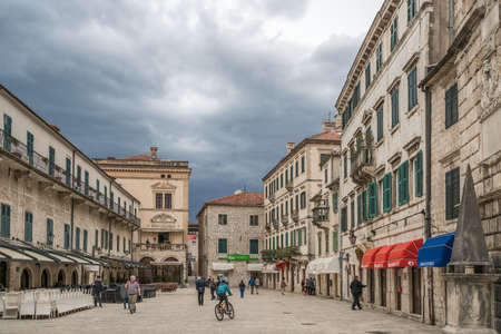 Kotor, Montenegro - April 2018 : Boy riding bicycle and people walking on the historical Square of Arms in the Old Townのeditorial素材