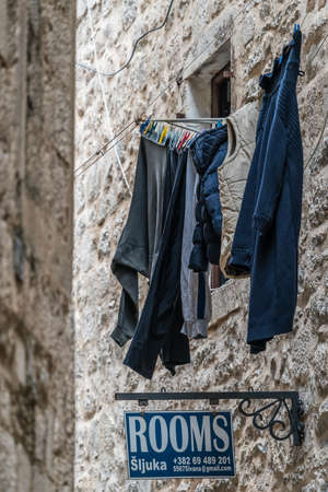 Kotor, Montenegro - April 2018 : Laundry drying on a clothesline above sign spelling rooms in the Old Townのeditorial素材