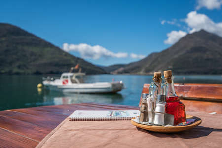 Perast, Montenegro - April 2018 : Old vintage glass bottles containing oil, vinegar, salt and pepper on a table in restaurantのeditorial素材