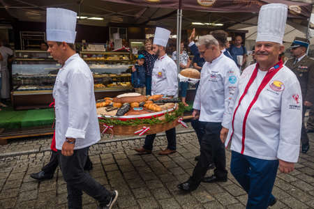 Jawor, Poland - August 2018 : Bakers dressed in white working outfits carrying wicker basket with breads during parade on the annual Bread and Gingerbread Festivalのeditorial素材