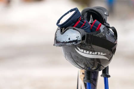 Szklarska Poreba, Poland - February 2019 : Ski helmet, gloves, googles and ski poles left in the...