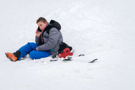 Szklarska Poreba, Poland - February 2019 : Young boy calling for help on his mobile phone after...